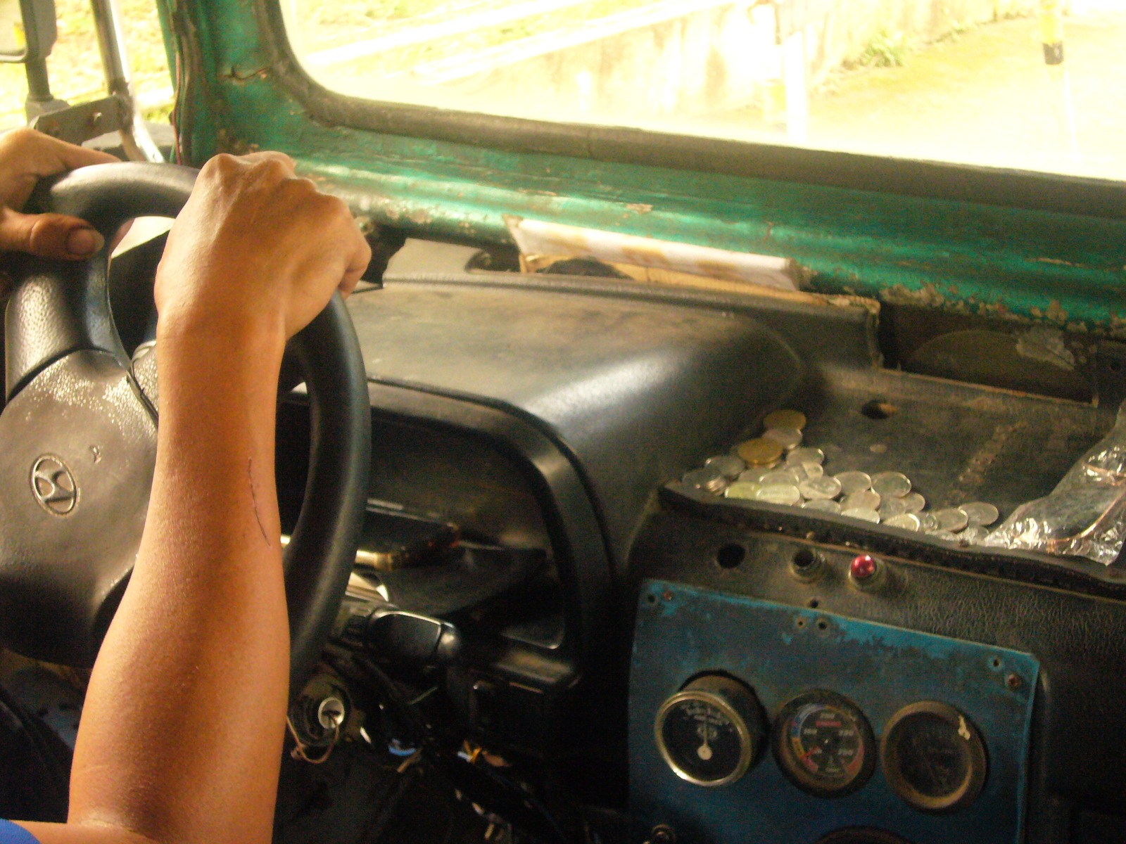 A jeepney driver with his hands on the steering wheel